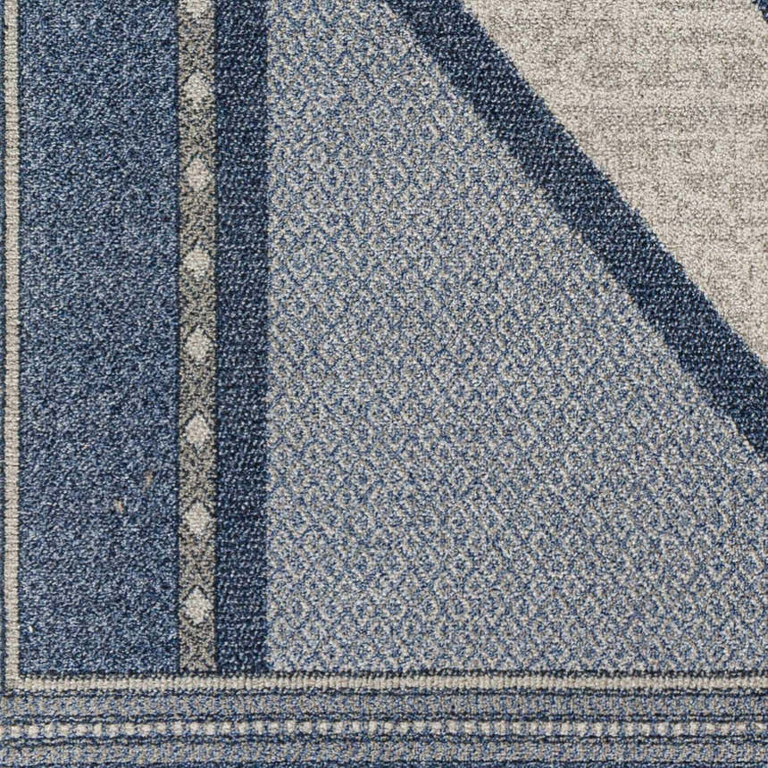 Close-up of the Onan Area Rug. Features a geometric pattern in arctic sky, gray, light gray, and silver tones. Swatch