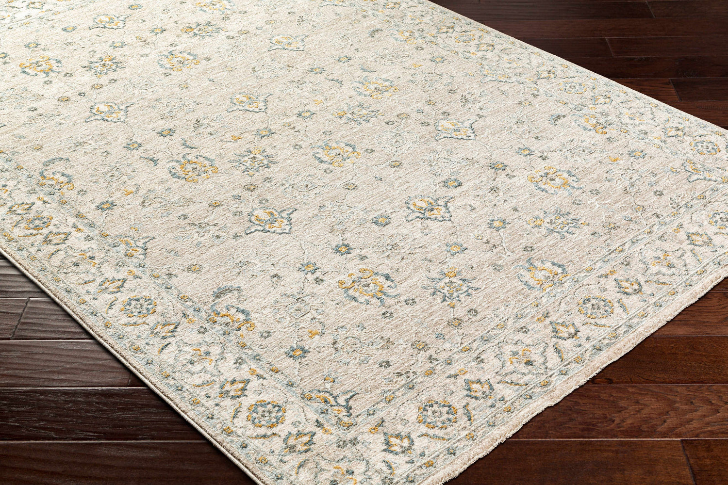 Close-up of Amaru Cream & Sage Textured Rug. Features a traditional floral pattern with sage, cream, and mustard tones. Corner