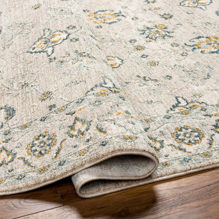 Close-up of Amaru Cream & Sage Textured Rug showing its traditional floral pattern and soft, neutral colors. Fold
