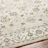 Close-up of the Amaru Cream & Sage Textured Rug with Fringes, showing floral pattern and soft, neutral colors. Texture