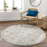 Light-filled room with round Annie Cream Textured Rug, wood floors, and a stylish chair with a blue pillow. Roomscene-Round