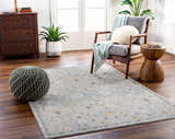 Living room scene with Annie Green Textured Rug, gray chair, wood accents, and plants. Roomscene-Rectangle