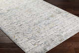 Close-up of the Chaka Textured Rug in off white, light gray, teal, and mustard on a dark wood floor. Corner