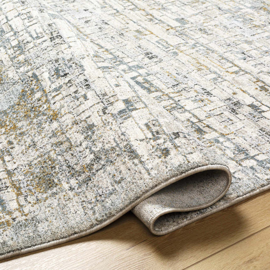 Close-up of Chaka Textured Rug in light gray, ink blue, and mustard on wood floor. Contemporary style. Fold