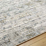 Close-up of the Chaka Textured Rug with Fringes. Features off white, gray, and mustard hues in a contemporary design. Texture