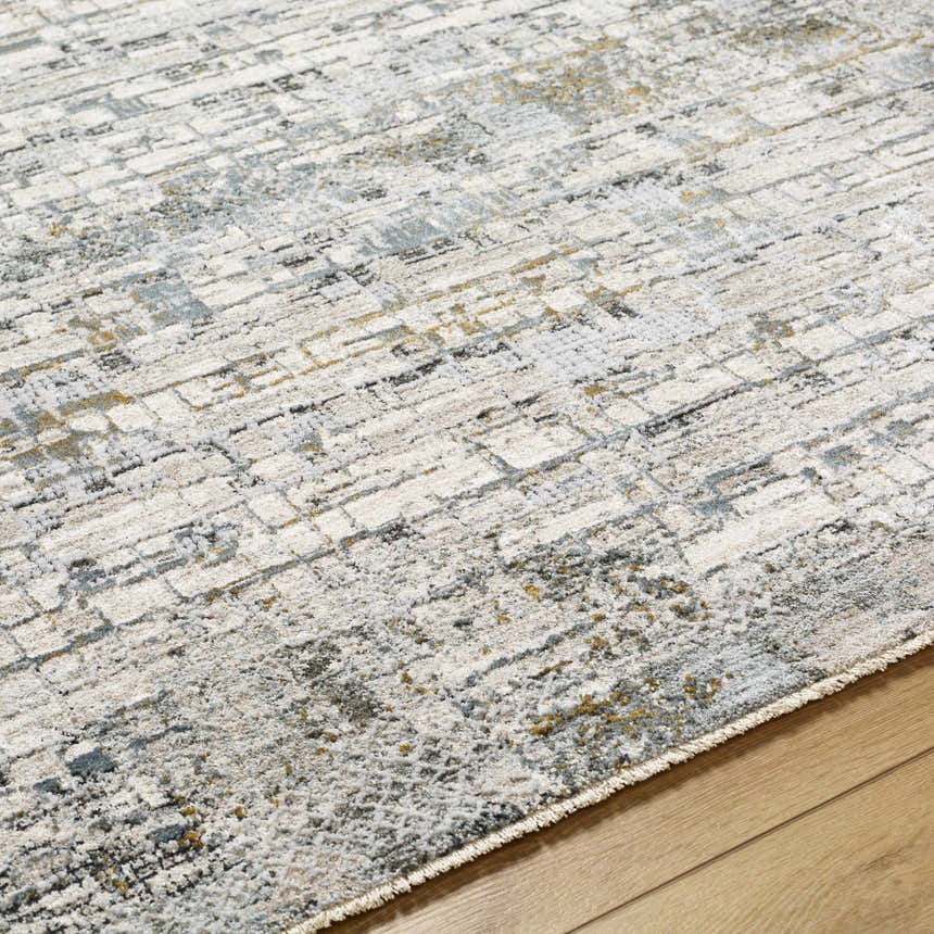 Close-up of the Chaka Textured Rug with Fringes. Features off white, gray, and mustard hues in a contemporary design. Texture
