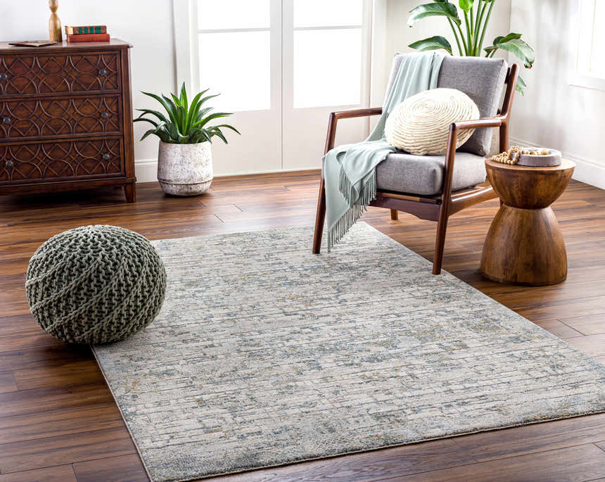 Living room scene with a Chaka Textured Rug, gray armchair, and wooden accents. Roomscene-Rectangle