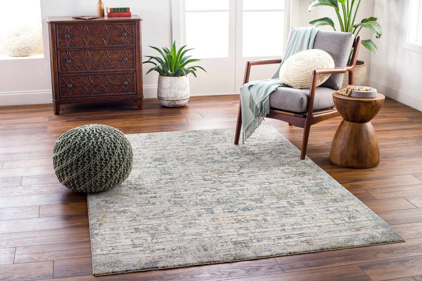 Living room scene with a Chaka Textured Rug in light gray and blue tones, styled with a mid-century modern chair. Roomscene-Rectangle