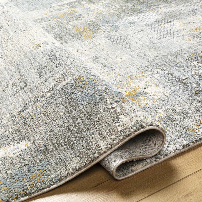 Close-up of the Elina Textured Abstract Rug. Colors include dusty sage, ink blue, and mustard. Contemporary style. Fold
