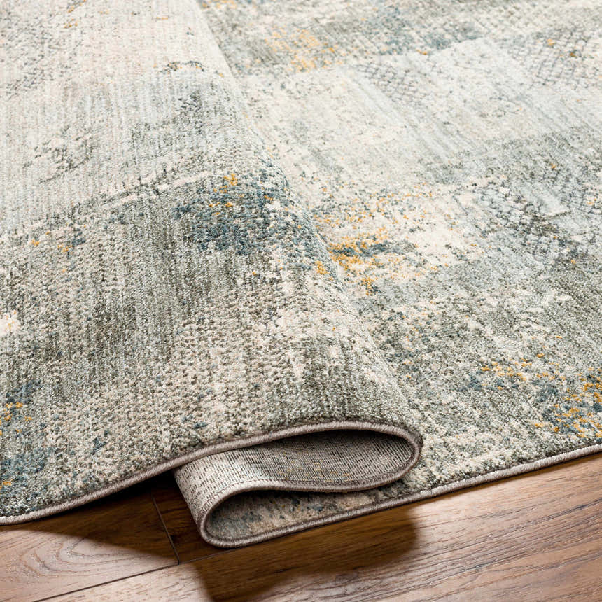 Close-up of the Elina Textured Abstract Rug showing the dusty sage, blue, and mustard colors and textured weave. Fold