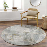 Modern living room scene with a round Elina Textured Abstract Rug in gray, blue, and mustard tones. Roomscene-Round