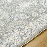 Close-up of the Gauge Gray Blue Textured Rug showing the traditional floral pattern and soft, neutral color palette. Texture