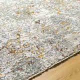 Close-up of the Moke Textured Rug in gray with camel and clay accents, showing its woven texture on a wood floor. Texture