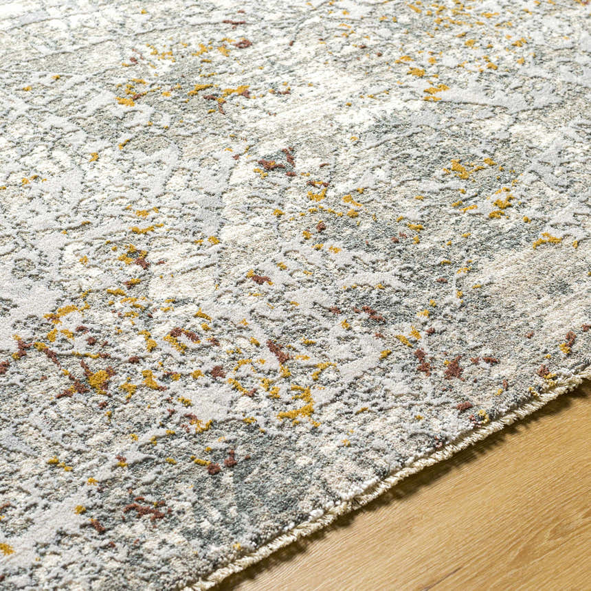 Close-up of the Moke Textured Rug in gray with camel and clay accents, showing its woven texture on a wood floor. Texture