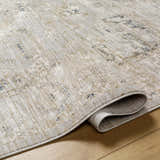Close-up of the Gioia Area Rug showing its beige, bone, and blue traditional pattern and machine woven texture. Fold