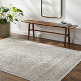Entryway with a Kazou Gray Medallion Area Rug, wood bench, mirror, and potted plant creating a welcoming, neutral-toned space. Roomscene-Rectangle