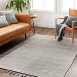 Living room scene with a beige Anaya area rug, leather sofa, chair, and wood floors. Farmhouse style. Roomscene-Rectangle