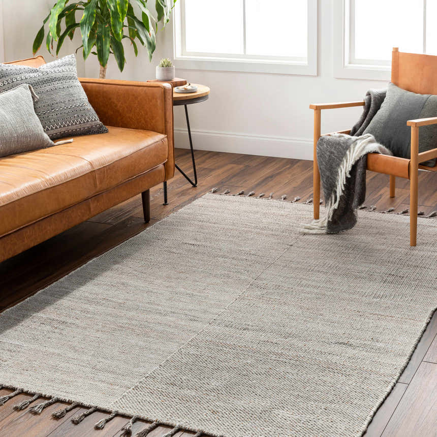 Living room scene with a beige Anaya area rug, leather sofa, chair, and wood floors. Farmhouse style. Roomscene-Rectangle