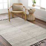 Neutral room scene with Anaya Beige area rug, woven chair, and wood side table on dark wood floors. Roomscene-Rectangle