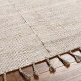 Close up of the Anaya Beige Area Rug showing hand woven texture and tassel details. Texture