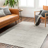 Living room scene with a brown leather sofa and Anaya Cream Area Rug on dark wood floors. Roomscene-Rectangle