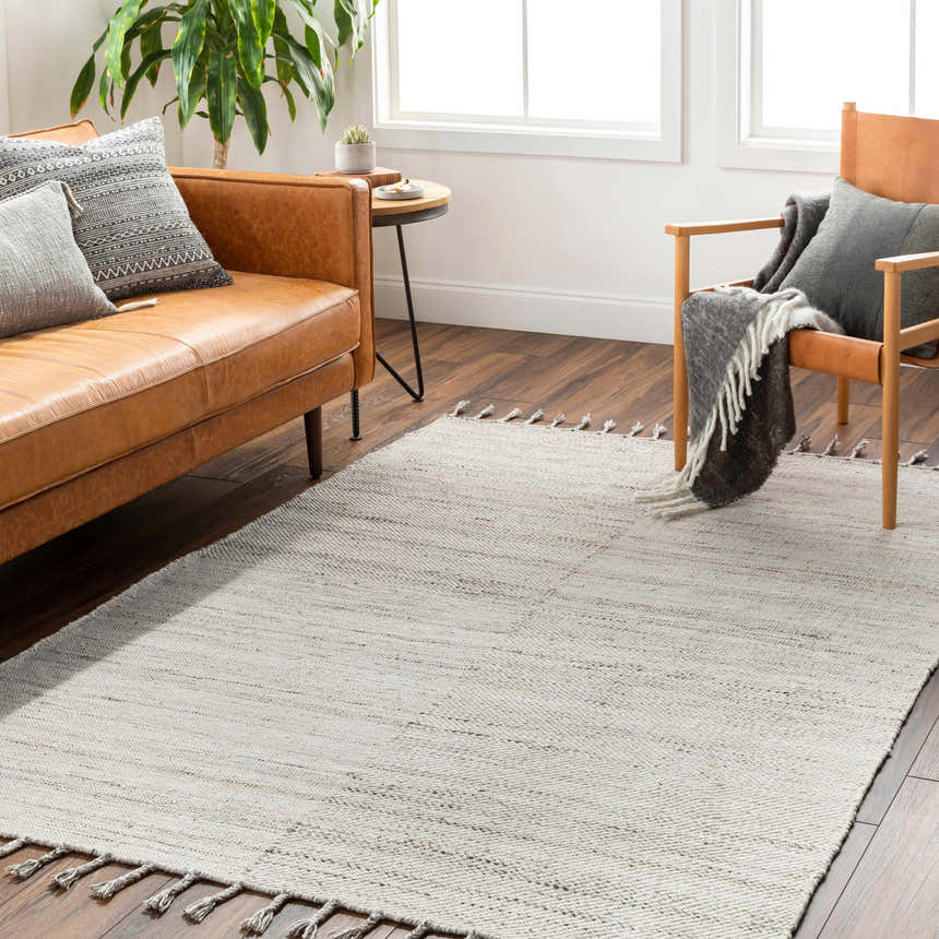 Living room scene with a brown leather sofa and Anaya Cream Area Rug on dark wood floors. Roomscene-Rectangle
