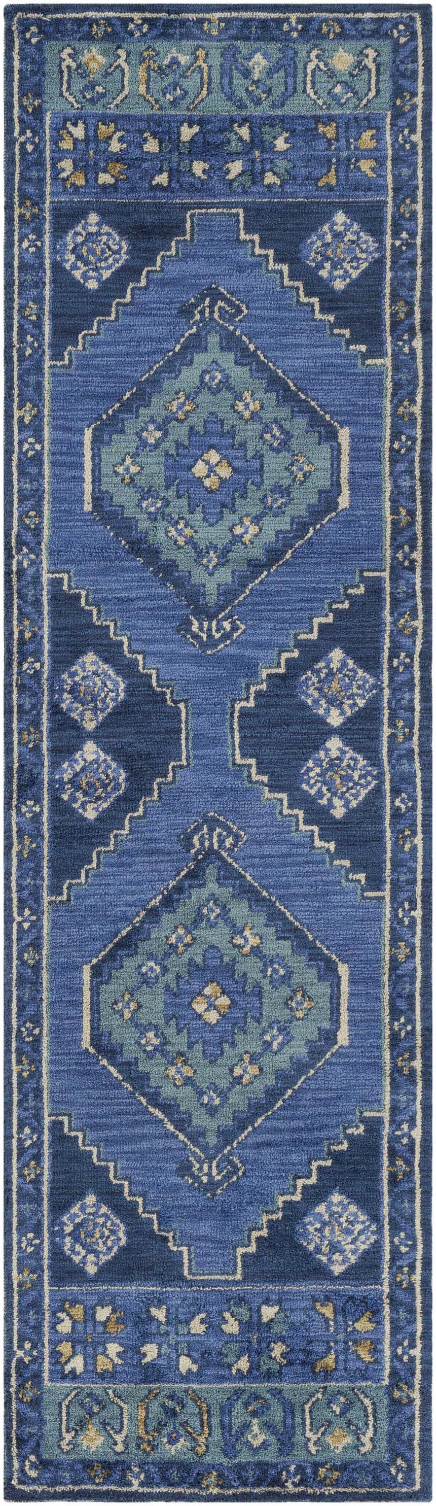 Close-up of the Selden Area Rug, featuring a geometric pattern in shades of blue, teal, and cream. Design-Runner-38