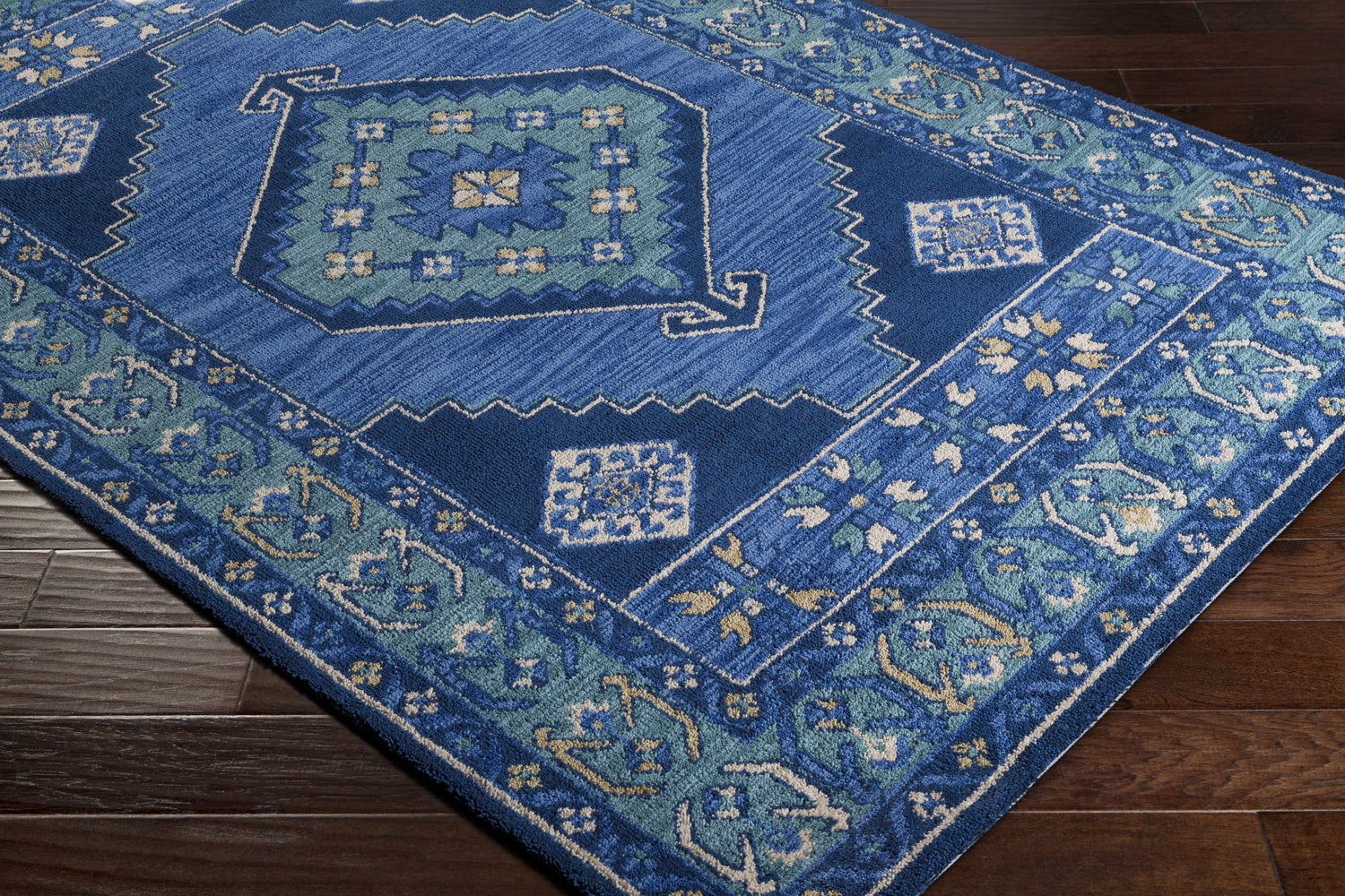 Close-up of the Selden Area Rug, a blue rug with a geometric pattern and a soft, textured pile. Corner