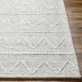 Close-up of Kyung Gray Area Rug showing hand woven texture and geometric pattern on wood floor. Front