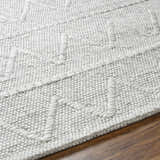 Close up of the hand woven Kyung Gray Area Rug showing the light gray color and textured geometric pattern. Texture