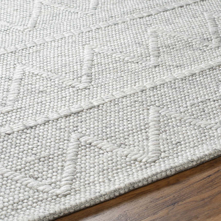 Close up of the hand woven Kyung Gray Area Rug showing the light gray color and textured geometric pattern. Texture