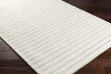 Close-up of the hand-woven Laleh Cream Area Rug showing its beige color, subtle pattern, and textured wool blend. Corner