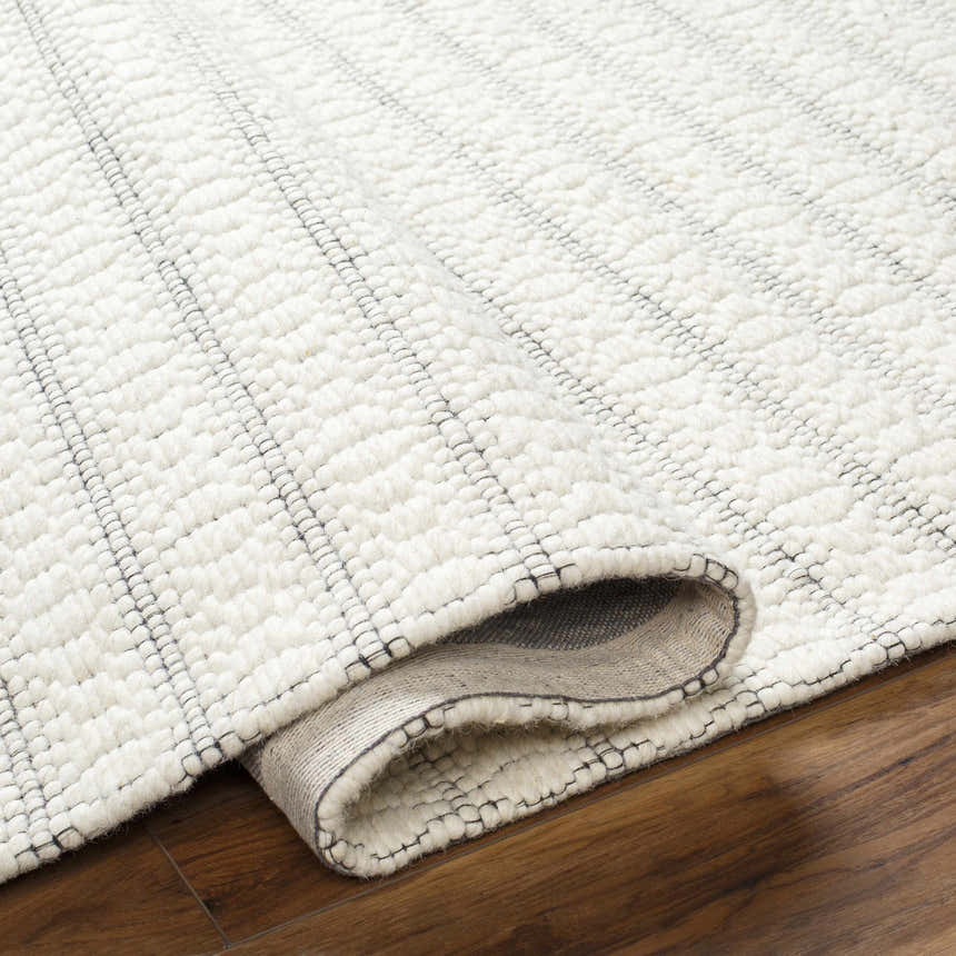 Close-up of the Laleh Cream Area Rug showing its woven texture, beige color, and geometric stripe pattern. Fold