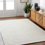 Entryway with wood floors and a Laleh Cream Area Rug, light wood cabinet, and potted snake plant. Roomscene-Rectangle
