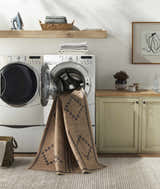 Laundry room with Fathi Washable Area Rug in camel and brown partially inside the washing machine. Farmhouse style decor. Washing-Machine