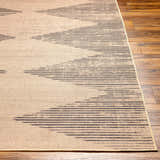 Close-up of the Ijlal Washable Area Rug in camel and dark brown, featuring a linear geometric pattern on wood floors. Front