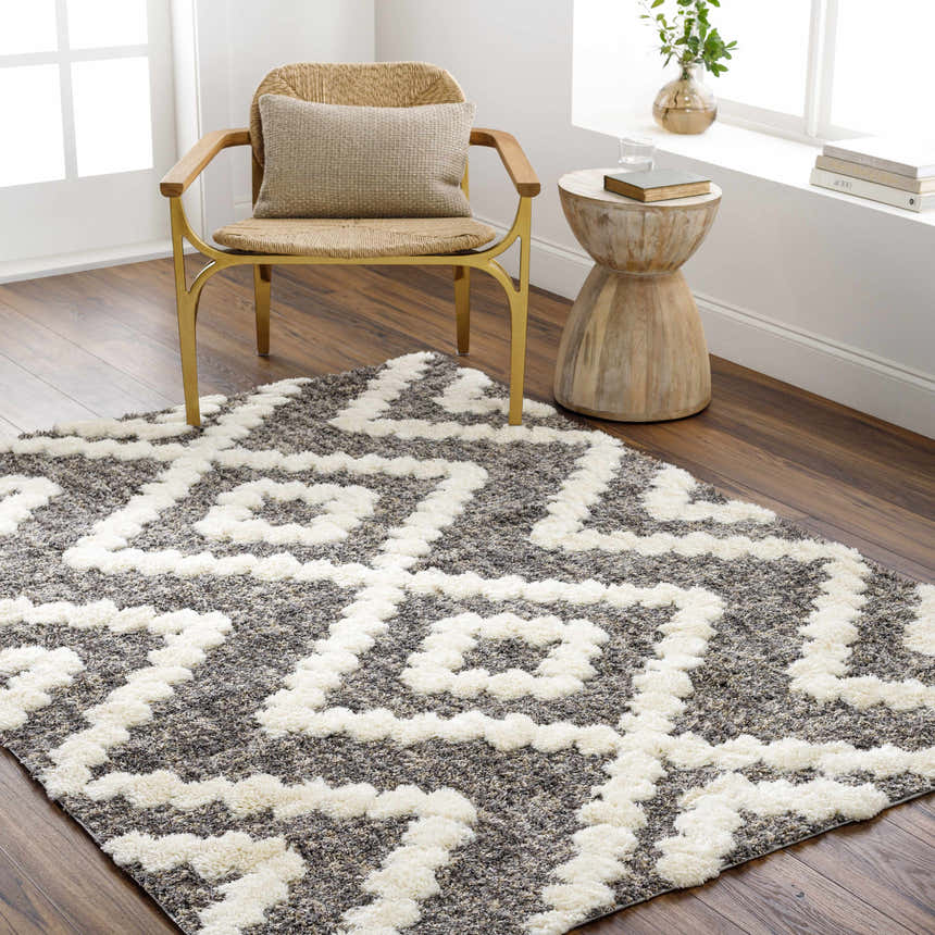 Farmhouse-style room with a Rian Brown Area Rug, woven chair, and wood side table on a dark wood floor. Roomscene-Rectangle