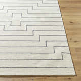 Close-up of the hand-tufted Wyome Area Rug. Off-white wool rug with a gray geometric, maze-like pattern. Farmhouse style. Front