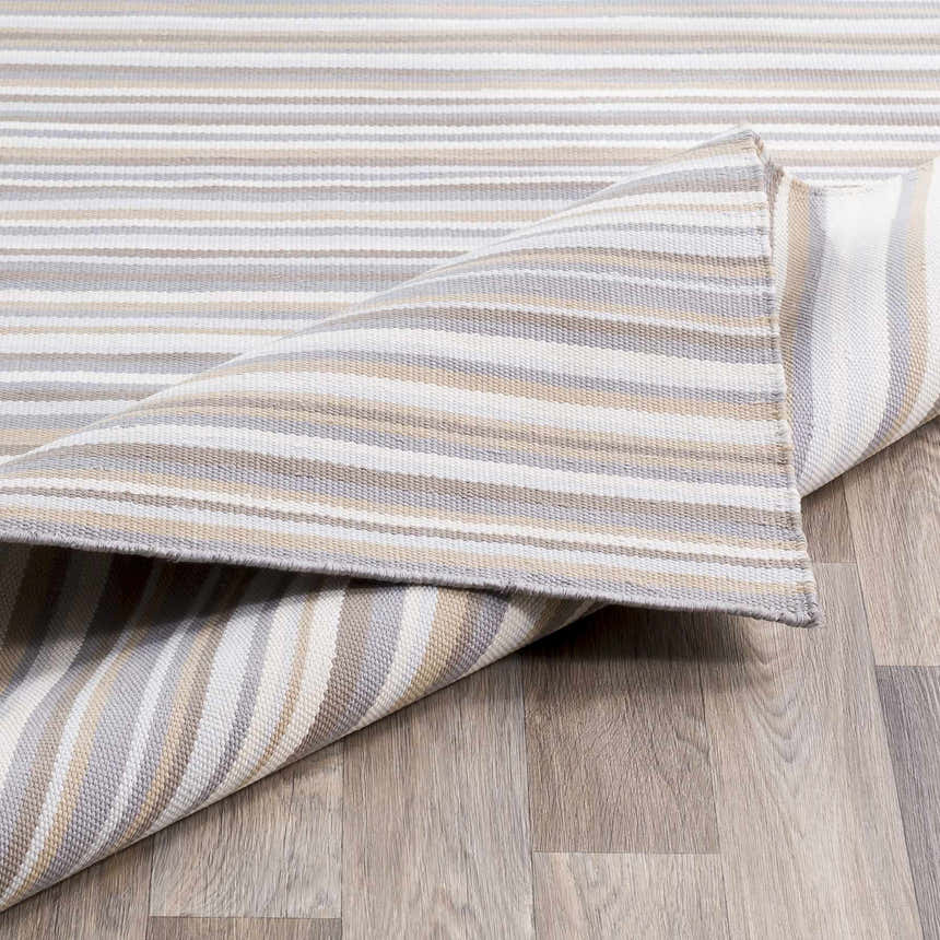 Close-up of the hand-woven Shawville Area Rug, featuring brown, gray, tan, and white stripes on a wood floor. Front