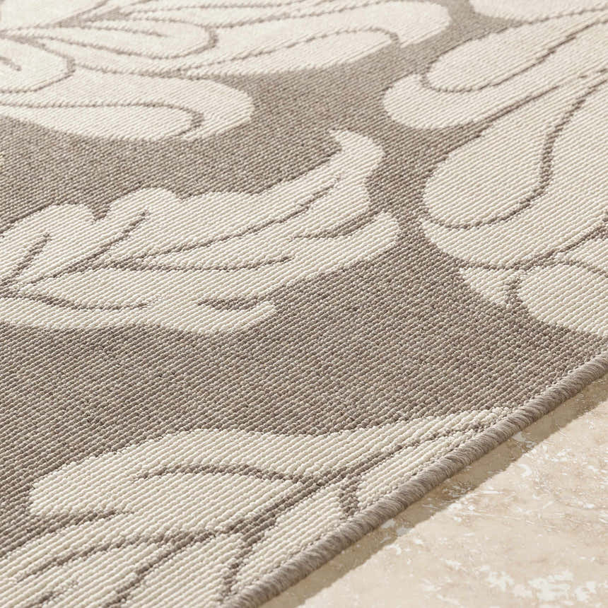 Close-up of the Sherard Area Rug, featuring a beige and dark red floral pattern and machine-woven texture. Texture