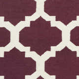 Close-up of the Shotton Area Carpet showing a dark purple and ivory geometric pattern. Hand woven wool texture. Swatch