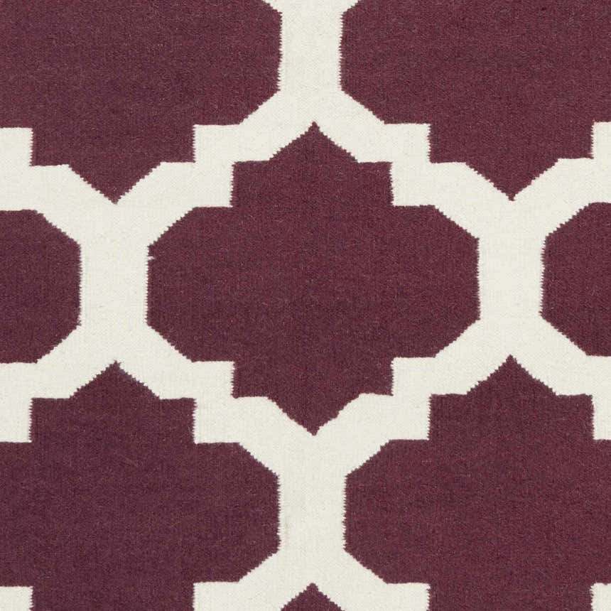 Close-up of the Shotton Area Carpet showing a dark purple and ivory geometric pattern. Hand woven wool texture. Swatch