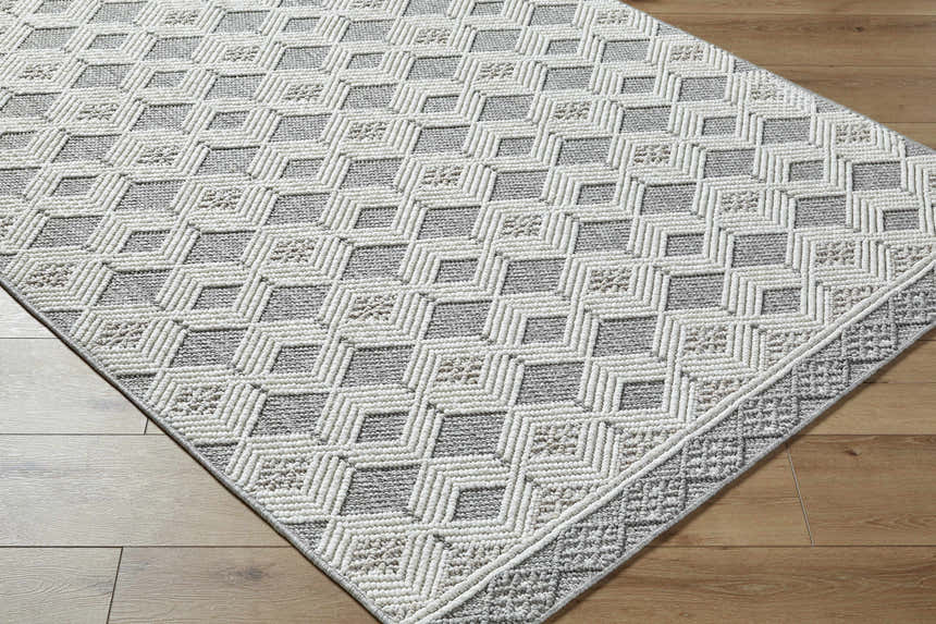 Close up of Salil Ivory Area Rug showing geometric diamond pattern and textured cream and light gray yarns. Corner