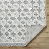 Close-up of the Salil Ivory Area Rug showing the geometric diamond pattern and textured weave in cream, ivory, and light gray. Fold