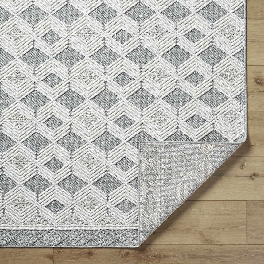 Close-up of the Salil Ivory Area Rug showing the geometric diamond pattern and textured weave in cream, ivory, and light gray. Fold