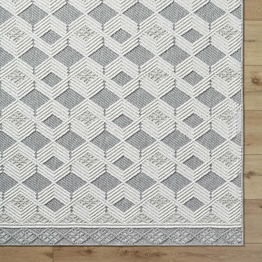 Close-up of the Salil Ivory Area Rug, showcasing its geometric diamond pattern in cream, ivory, and light gray tones. Corner