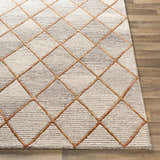 Close-up of the hand-tufted Sharpes Area Rug. Geometric diamond pattern in brown, mustard, and orange on a wool rug. Front