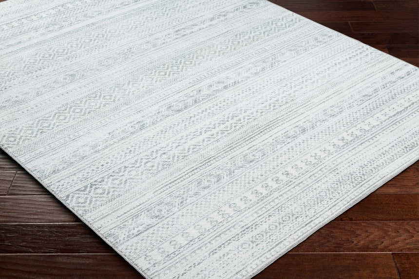 Close up of Gizeh Silverton Washable Area Rug. Farmhouse style rug with cloud gray and silverton geometric pattern. Corner