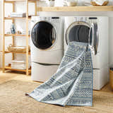 Laundry room scene with Ianna Arctic Stone Washable Area Rug spilling from dryer onto a jute rug. Farmhouse style. Washing-Machine