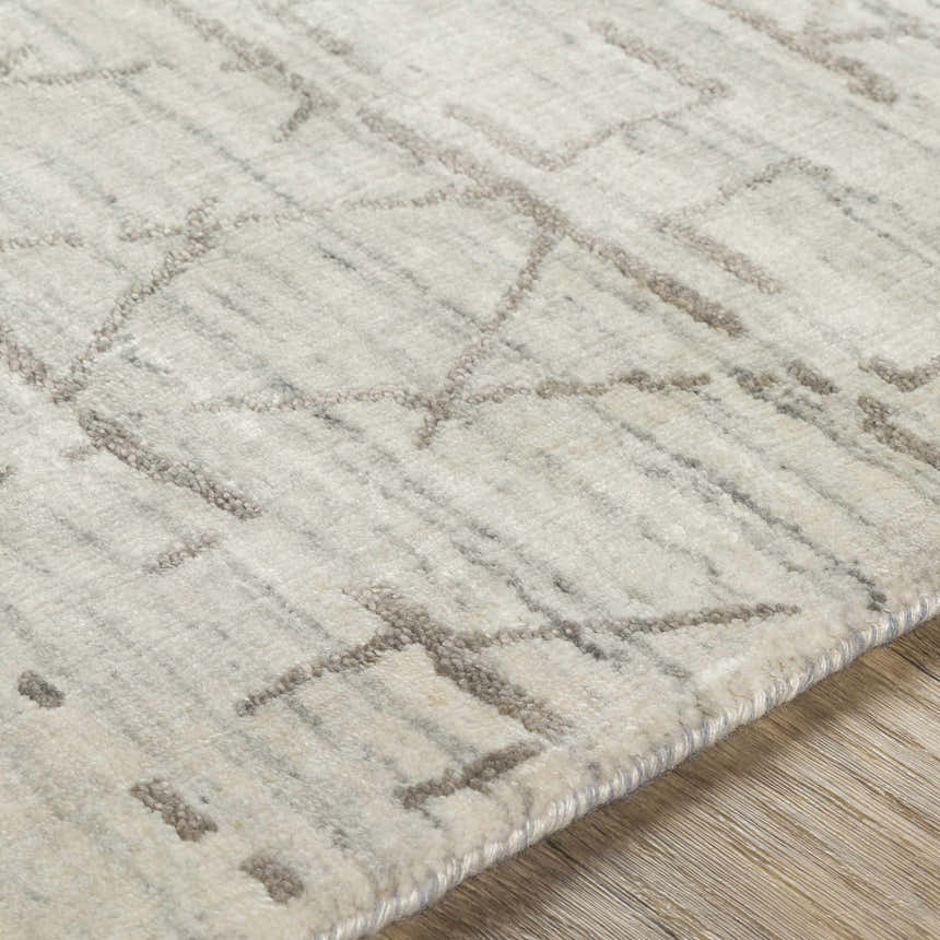 Close-up of the Shortland Premium Area Rug. Hand-loomed cotton and viscose rug with a geometric gray and ivory pattern. Texture